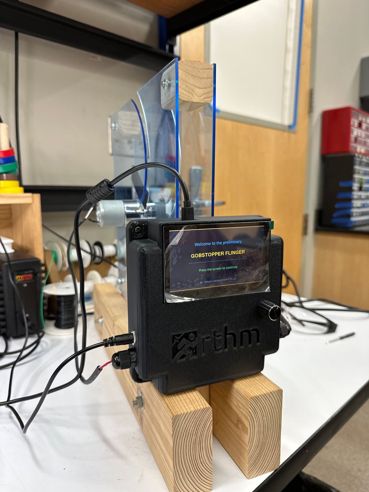 The launcher on its wooden stand, with the touchscreen showing the Gobstopper Flinger start screen